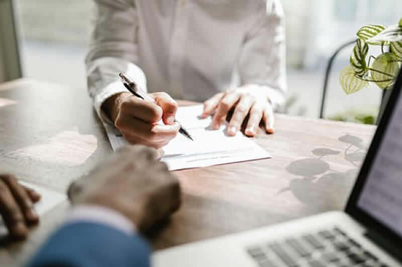 Two people at a desk handling paperwork - Transfer on Death Accounts: A Probate Avoidance Tool?