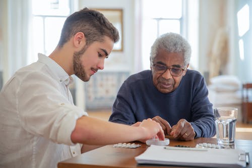 A young man helping a senior man; New York Community Medicaid: Essential Insights